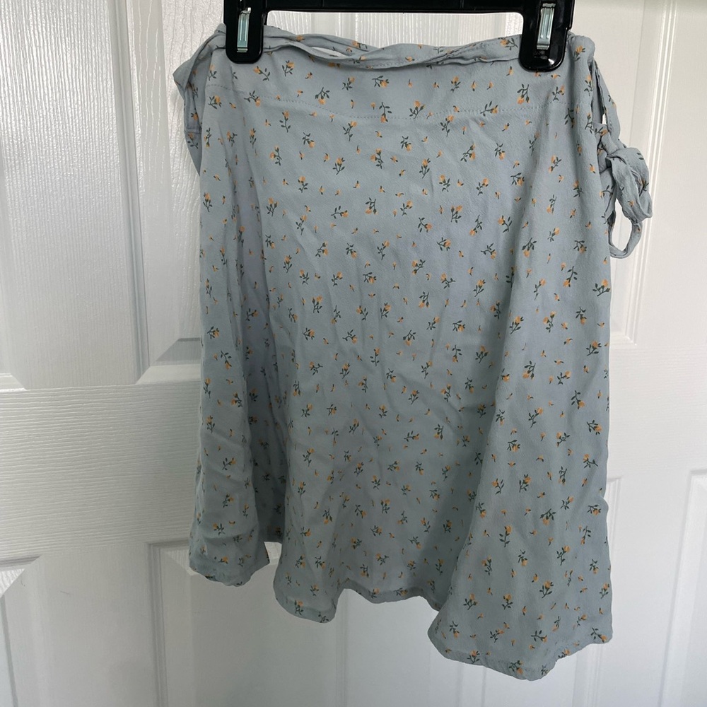 The skirt is light blue with a floral print and one size from brandy melville
